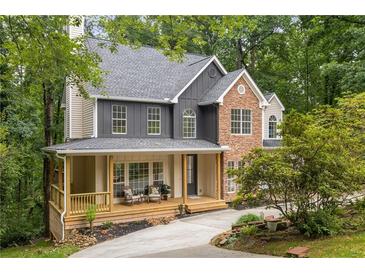 Charming two-story home with a welcoming front porch and a mix of stone and siding accents at 5560 Pilgrim Point Ext, Cumming, GA 30041