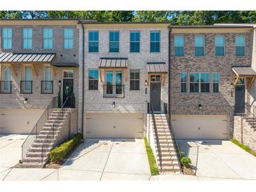 Beautiful townhome exterior with brick facade, front-entry garage, and well maintained landscaping at 3982 Carver Cir, Doraville, GA 30360