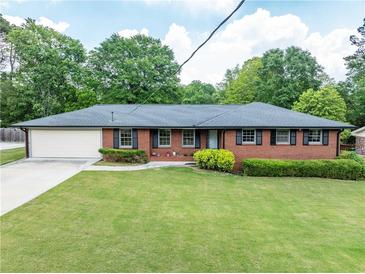 Charming single-story brick home featuring a well-manicured front lawn and attached garage at 3089 Ranlo Dr, Atlanta, GA 30340