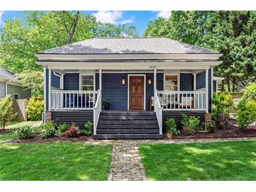 Charming home featuring a welcoming front porch, wood door, landscaped front yard, and fresh curb appeal at 2647 Forrest Nw Ave, Atlanta, GA 30318