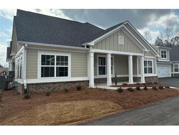 Charming single-story home featuring a covered porch, manicured landscaping, and neutral color palette at 1001 Calypso Way # 1001, Cumming, GA 30040