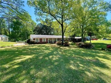 Charming brick home with a well-manicured lawn and mature trees creating a serene and inviting atmosphere at 3233 Bolissa Dr, Atlanta, GA 30340