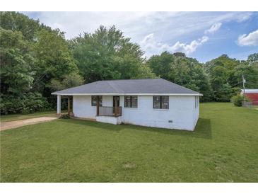 Charming single-story home with a well-maintained lawn and mature trees in a serene setting at 405 Emory St, Oxford, GA 30054