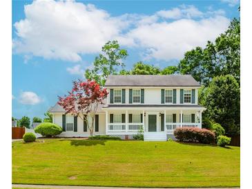 Charming two-story home with a beautifully landscaped yard, front porch, and classic green shutters at 855 Madison Chase Way, Lawrenceville, GA 30045