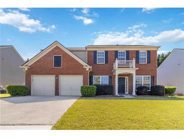 Charming two-story brick home with a well-manicured lawn, two-car garage, and inviting front porch at 310 Hammersmith Dr, Suwanee, GA 30024