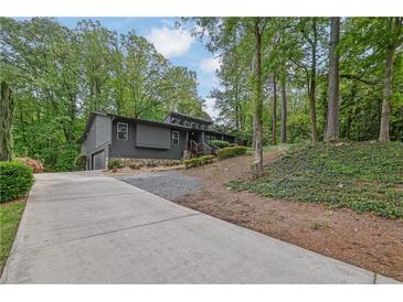 Contemporary home featuring a stylish exterior, two-car garage, landscaped front yard, and a lengthy concrete driveway at 3165 Brookview Dr, Marietta, GA 30068