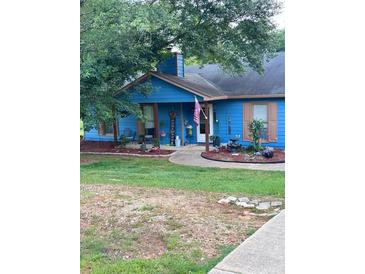 Charming blue house featuring a covered front porch and a well-maintained lawn at 483 Glen Terrace Rd, Auburn, GA 30011