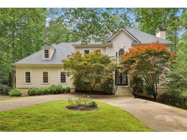 Charming two-story traditional home with a circular driveway and lush, mature landscaping at 200 River Pass Trl, Atlanta, GA 30350