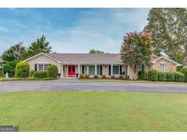 Charming single-story home with well-manicured lawn and a bright red front door at 3898 Bay Creek Rd, Loganville, GA 30052