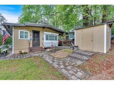 Charming home featuring a lovely yard, stone walkway, and shed at 5400 Kings Camp Rd Se #C1 Se Rd, Acworth, GA 30102