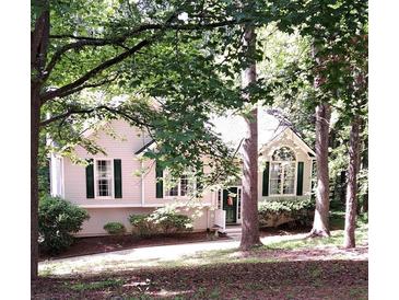 Charming home with green shutters and mature trees in a tranquil, wooded setting at 90 Camden Woods Pl, Dallas, GA 30157