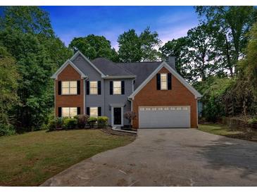 Charming two-story home with brick and siding, black shutters, and a well-manicured lawn at 5705 Cannonero Dr, Alpharetta, GA 30005