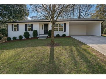 Charming home with a well-manicured lawn, white brick, a covered parking area, and black shutters at 1780 Kinridge Rd, Marietta, GA 30062