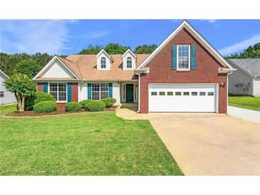 Charming brick and vinyl home featuring a well-manicured lawn and two-car garage at 2620 Matlin Way, Buford, GA 30519