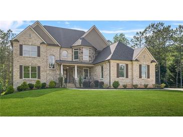 Stunning brick home featuring a manicured lawn and classic architectural details at 3298 Alcovy Club Ct, Dacula, GA 30019