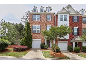 Charming brick townhome with attached garage, manicured landscaping, and inviting curb appeal at 7812 Kiverton Pl, Atlanta, GA 30350
