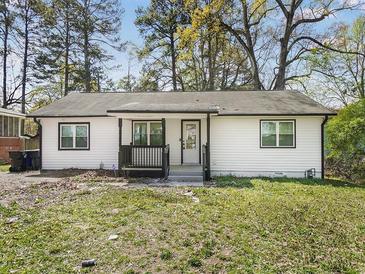 Charming single-story home featuring a tidy lawn and freshly painted black and white exterior at 117 Spring St, Stockbridge, GA 30281