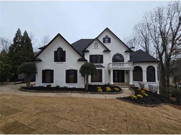 Stunning two-story home with a black roof, white facade, manicured lawn, and circular driveway at 7910 Tintern Trce, Duluth, GA 30097