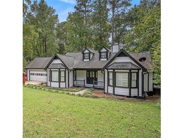 Charming two-story home with white siding, black trim, and a well-manicured front yard at 4902 Cedar Se Ct, Conyers, GA 30094