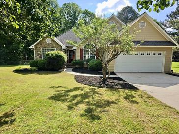 Charming single-Gathering home with a well-manicured lawn, landscaping, and attached two-car garage at 110 Orleans Blvd, Mcdonough, GA 30253