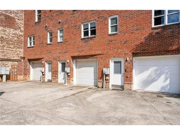 Back of building with multiple garages and entries on a concrete parking pad at 322 Peters Sw St # 6, Atlanta, GA 30313