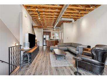 Open living room with exposed wood ceiling, modern furnishings, and seamless flow to the kitchen at 322 Peters Sw St # 6, Atlanta, GA 30313
