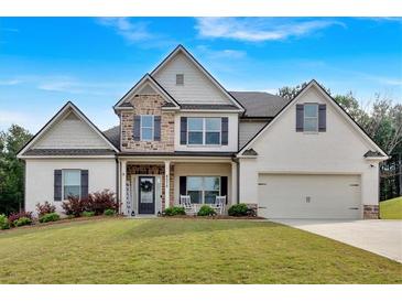 Charming two-story home with painted brick, stone accents, manicured lawn and front porch at 4575 Birch Way, Loganville, GA 30052