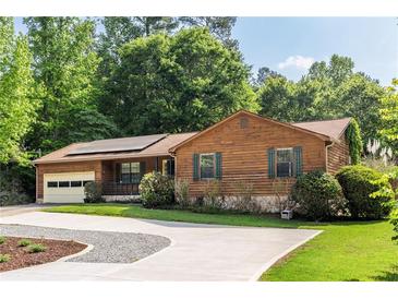 Charming wood and stone home featuring an attached garage, well-manicured lawn and a driveway at 522 Knollwood Dr, Stockbridge, GA 30281