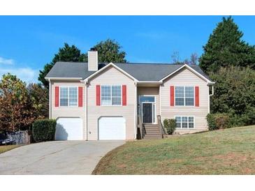 Charming two-story home with red shutters, two-car garage and well-maintained landscaping on a sunny day at 3238 Windgate Dr, Buford, GA 30519