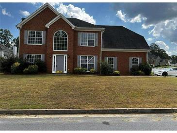 Charming two-story brick home with a well-manicured front yard and traditional architectural details at 500 Kings Pl, Riverdale, GA 30296