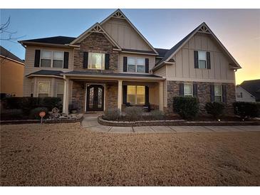 Inviting two-story home with stone accents, a covered porch, and a well-maintained front yard at 4316 Kershaw Dr, Snellville, GA 30039