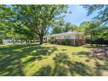 Well maintained home featuring a large front yard with mature trees and a classic brick facade at 2785 Toney Dr, Decatur, GA 30032