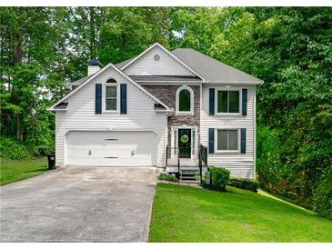 Charming two-story home with stone accents, a well-manicured lawn, and an attached two-car garage at 503 Hearthstone Rdg, Woodstock, GA 30189