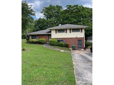 Split-level home with brick and siding, green lawn and mature trees at 2433 Tilson Rd, Decatur, GA 30032
