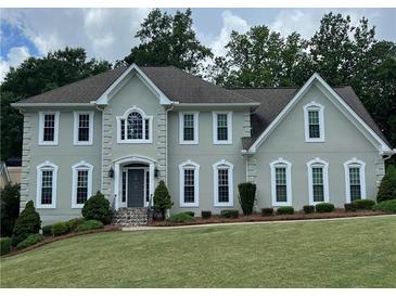 Charming two-story home featuring a well-manicured lawn and symmetrical window design at 3330 Arborwoods Dr, Alpharetta, GA 30022