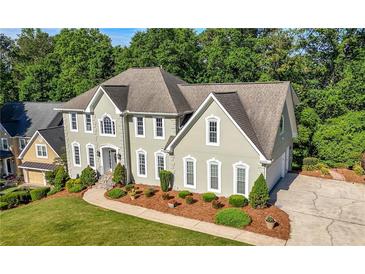 Charming two-story home featuring a manicured lawn, tasteful landscaping, and a welcoming, curved walkway at 3330 Arborwoods Dr, Alpharetta, GA 30022