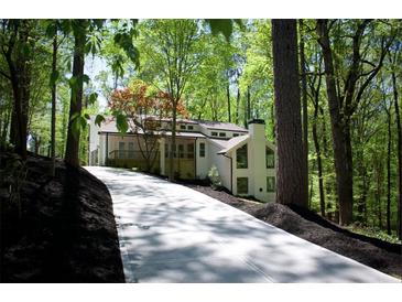Beautiful home exterior featuring a long driveway and lush surrounding trees at 3820 Fox Creek Ct, Marietta, GA 30062