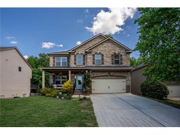 Charming two-story brick home featuring a front porch, attached garage, and a well-manicured lawn at 5655 Hedge Brook Dr, Cumming, GA 30028
