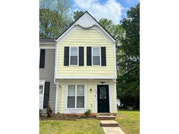Charming two-story home with a yellow facade and black shutters, complemented by a well-maintained front lawn at 458 Prince Of Wales, Stone Mountain, GA 30083