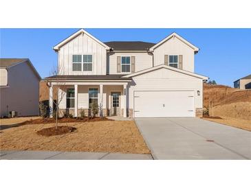 Charming two-story home features a covered front porch, a two car garage and professionally landscaped yard at 5587 Rosehall Pl, Atlanta, GA 30349
