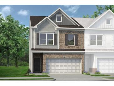 Charming exterior of a brick townhome with a two-car garage and a well manicured lawn at 24 Jacobs Farm Ln # 12, Lawrenceville, GA 30045