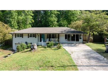 Charming ranch-style house featuring a brick facade, inviting front porch, and a well-maintained front yard at 3627 Groovers Lake Rd, Lithia Springs, GA 30122