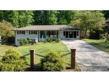 Charming single-story home with a well-manicured lawn and inviting curb appeal and long driveway at 3627 Groovers Lake Rd, Lithia Springs, GA 30122