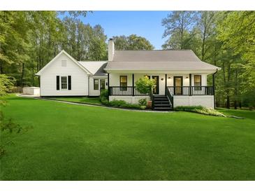 Charming single-story home featuring a well-manicured lawn, classic black and white trim, and a cozy front porch at 4615 Gresham Rd, Douglasville, GA 30134