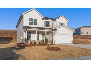 Charming two-story home featuring white siding, a covered porch, and an attached garage at 5599 Rosehall Pl, Atlanta, GA 30349