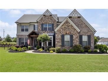 Charming two-story home with stone and brick facade, landscaped front yard, and decorative shutters at 320 Harvest View Ter, Woodstock, GA 30188
