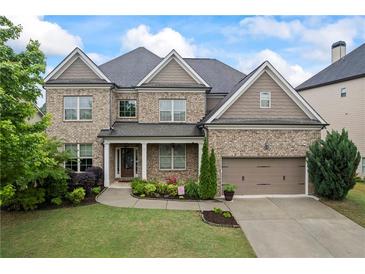 Charming brick two-story home featuring a manicured lawn, tidy landscaping and attached two car garage at 4769 Moon Hollow Ct, Buford, GA 30519
