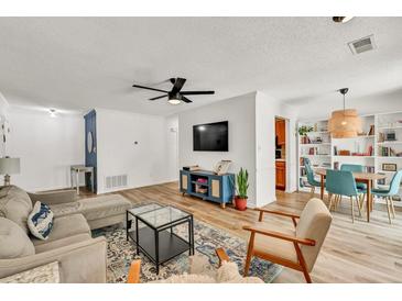 Bright living room with a cozy gray sofa, modern furnishings, and a dining area with stylish blue chairs at 1750 Clairmont Rd # 32, Decatur, GA 30033