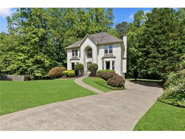 Charming two-story home featuring a well-manicured lawn and a welcoming driveway at 305 Jasmine Ct, Woodstock, GA 30189