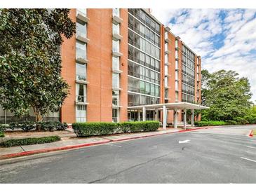 Brick building exterior featuring a covered entrance and manicured hedges and landscaping at 130 26Th St # 402, Atlanta, GA 30309